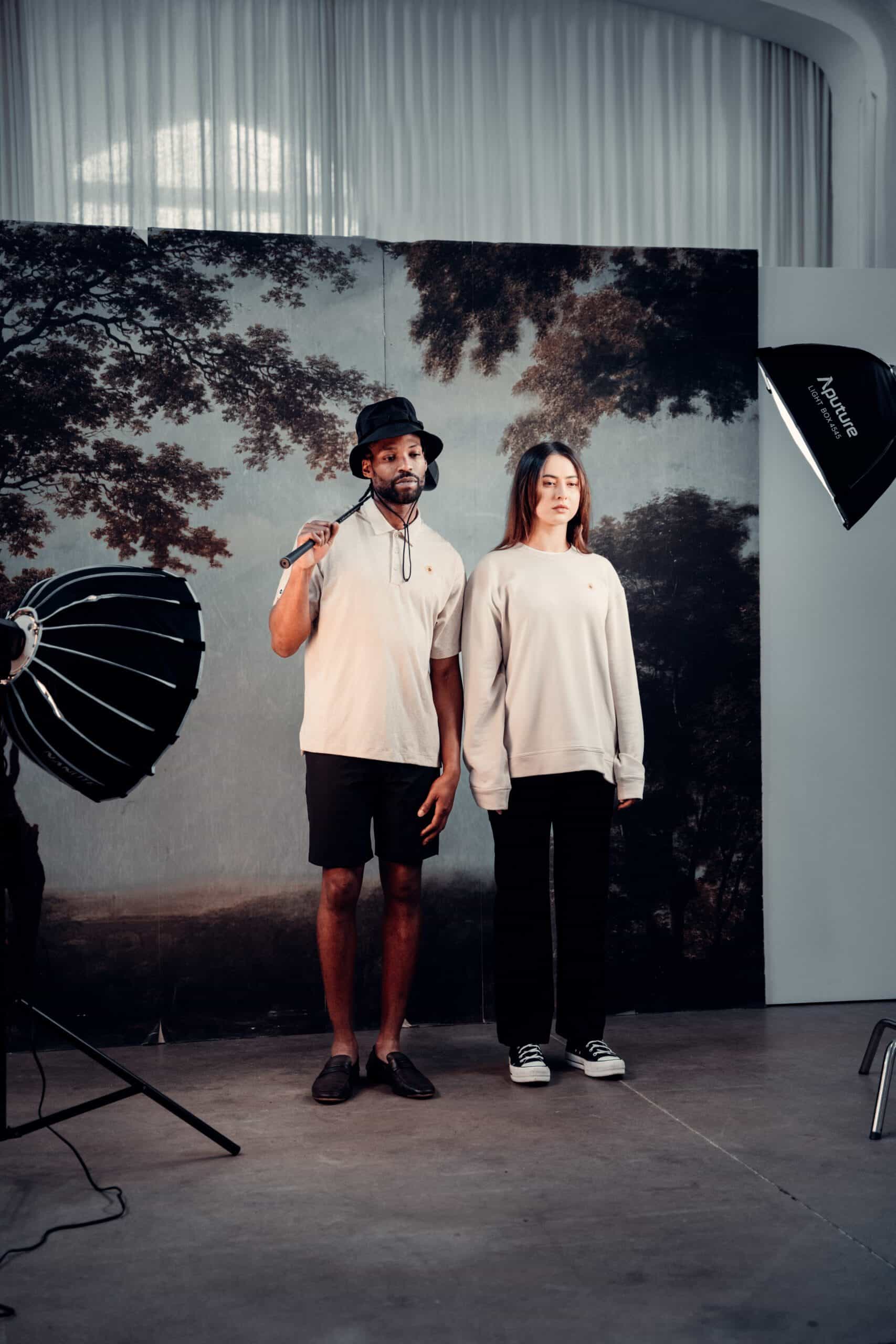 Two individuals, a man and a woman, posing together in a studio with professional lighting equipment.